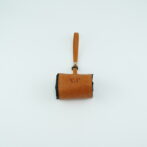 Small brown leather mini bag with a vertical strap, isolated on a light background (front view).