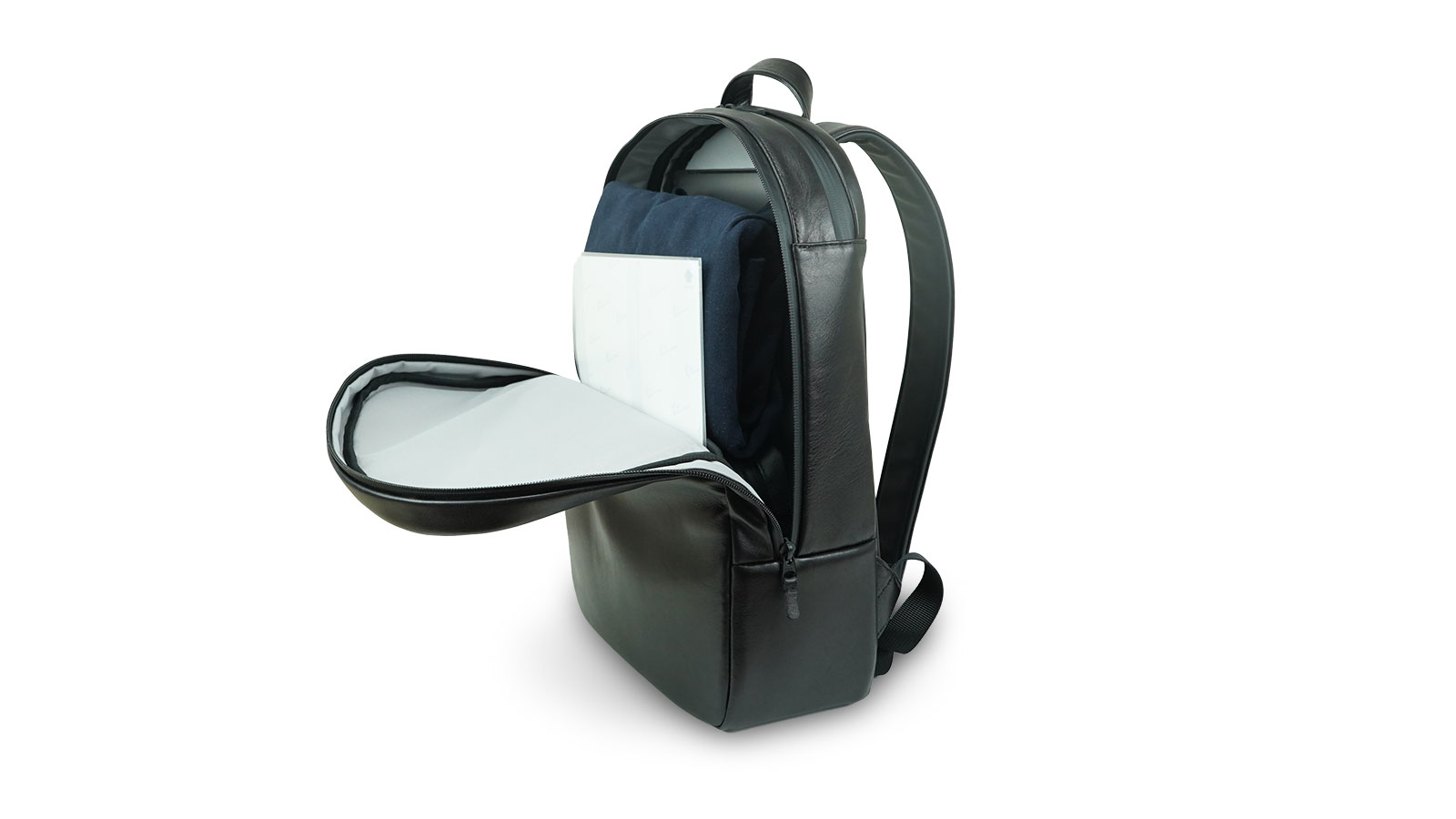 Black backpack opened to reveal a notebook and folded clothing inside.